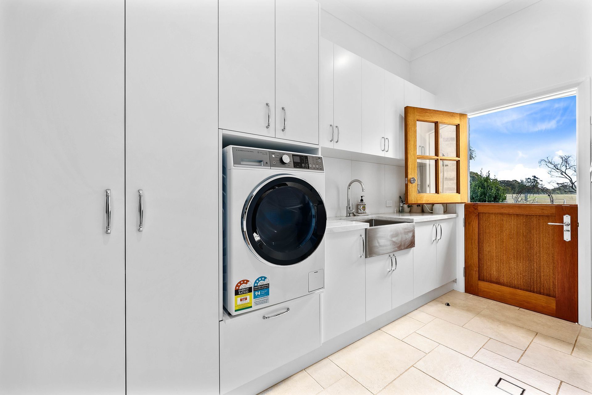 Bright Laundry Room With White Cabinets, Front-load Washer — Above & Beyond Interiors in Smeaton Grange, NSW