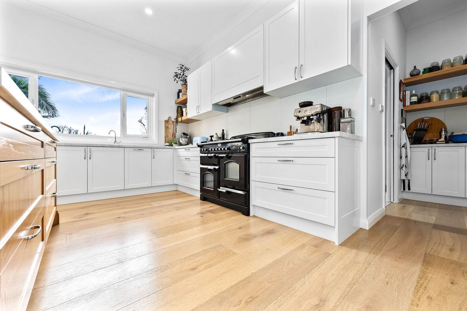 Bright Modern Kitchen With White Cabinets, Black Stove — Above & Beyond Interiors in Smeaton Grange, NSW