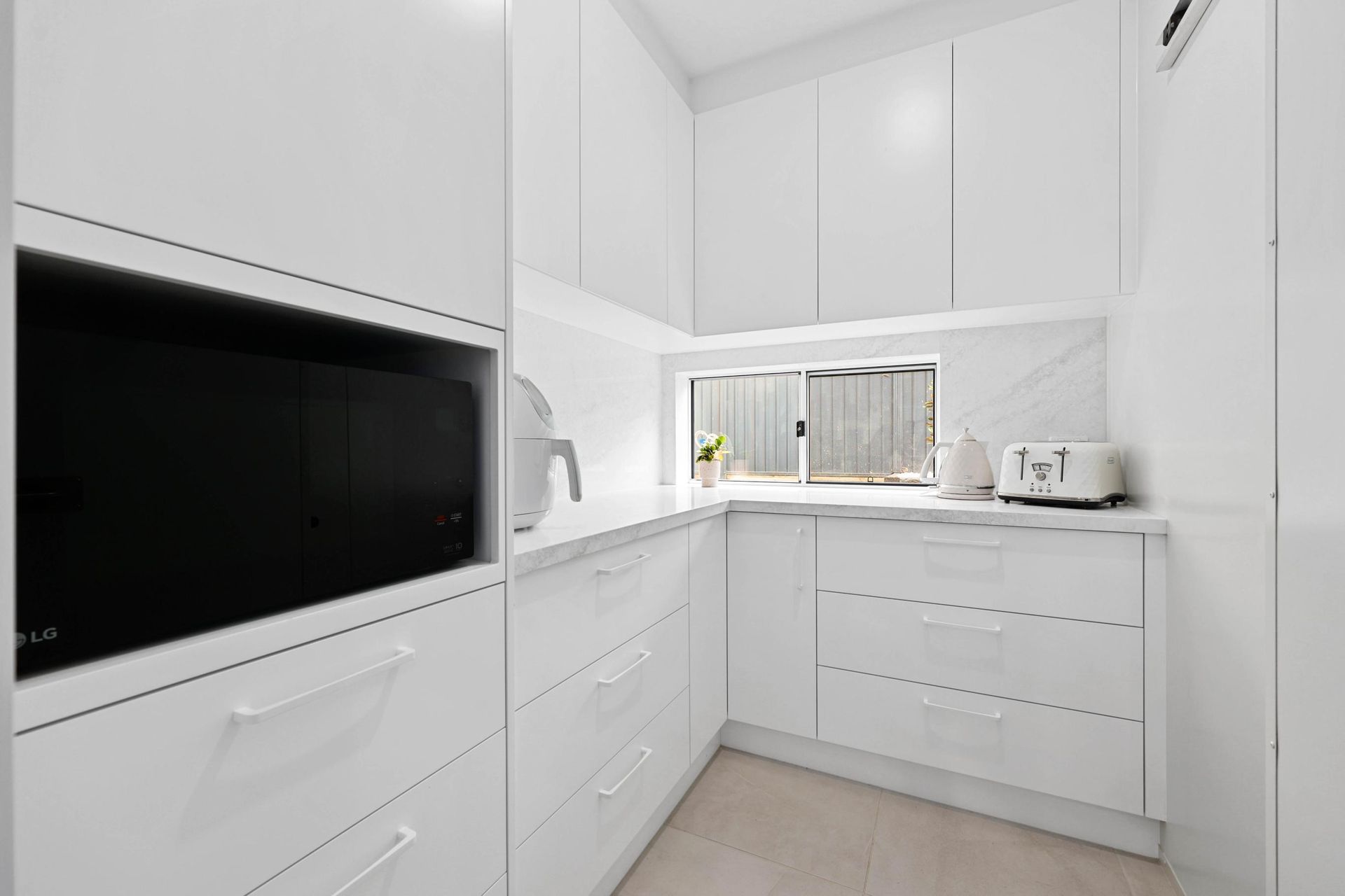 Bright White Modern Kitchen With Built-in Appliances — Above & Beyond Interiors in Smeaton Grange, NSW