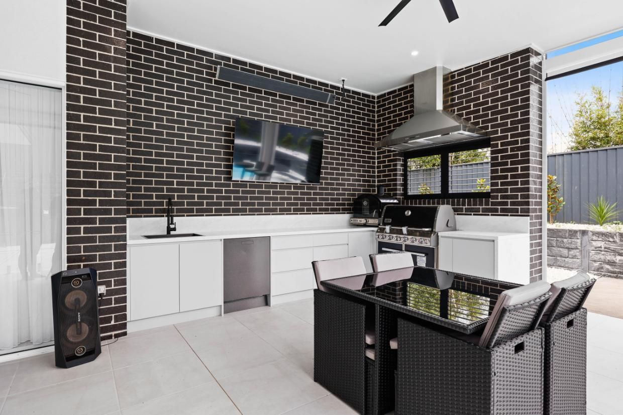 Modern Patio Kitchen With Black Brick Wall, White Cabinets — Above & Beyond Interiors in Smeaton Grange, NSW