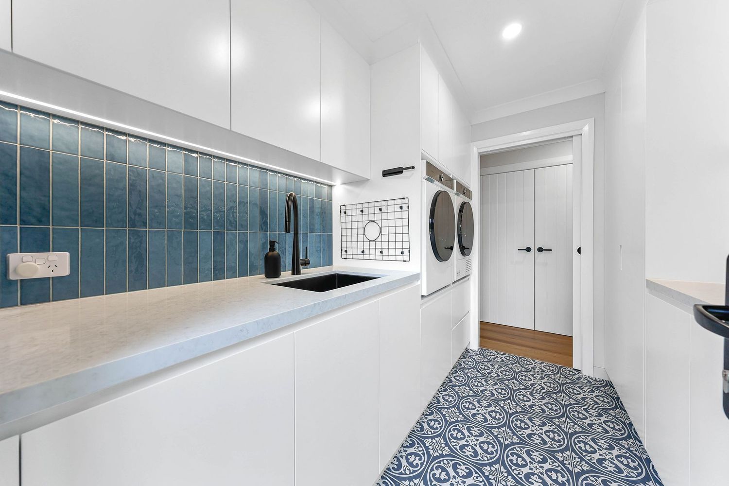 Bright Modern Laundry Room With Blue Tile Backsplash — Above & Beyond Interiors in Smeaton Grange, NSW