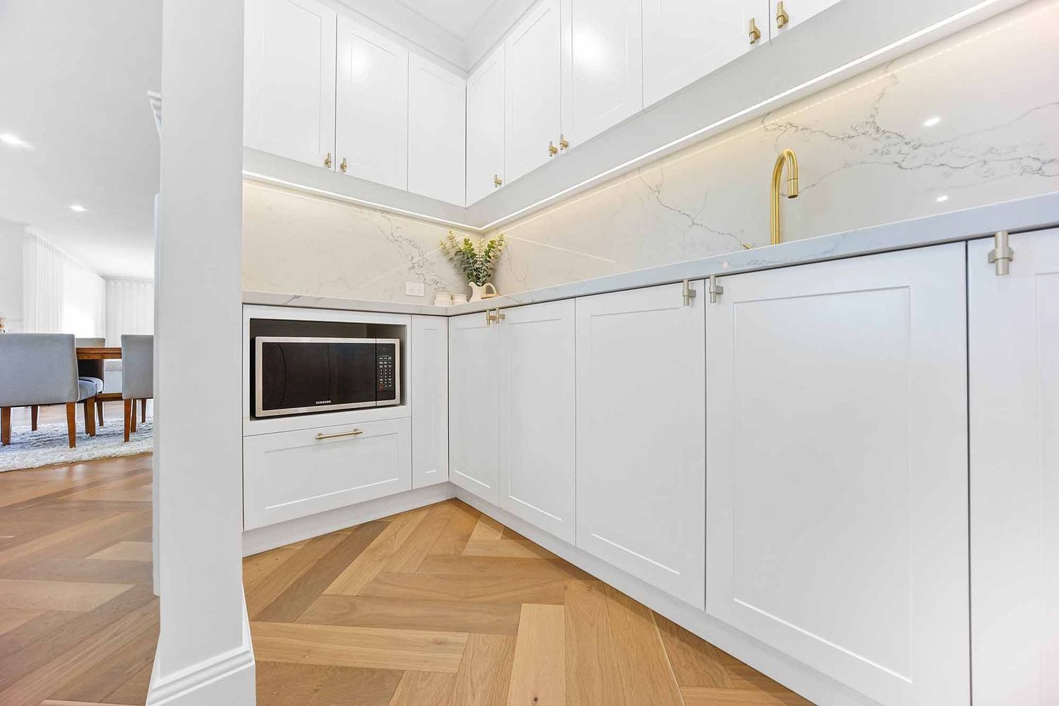 Bright White Kitchen With Gold Faucet, Built-in Oven — Above & Beyond Interiors in Smeaton Grange, NSW
