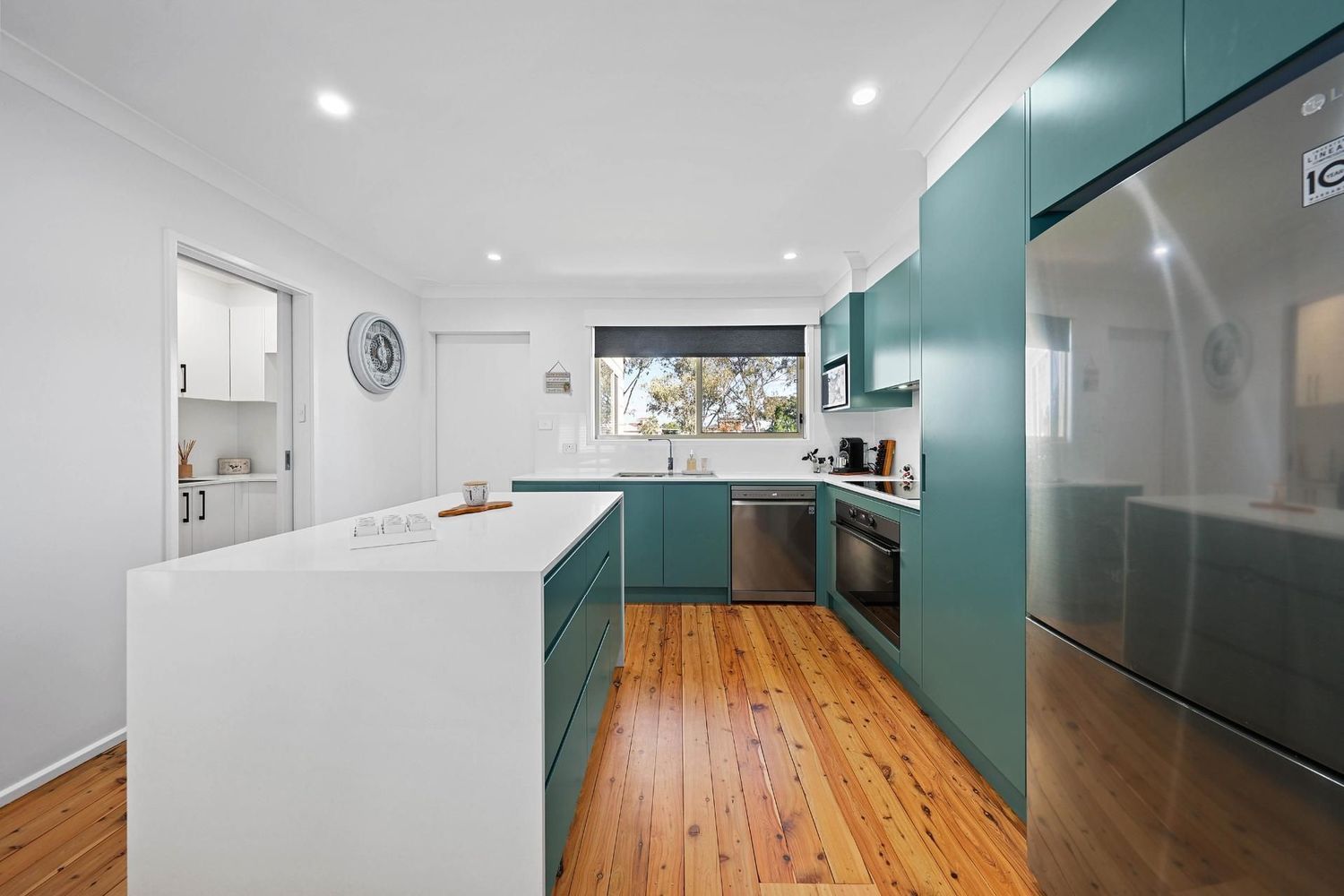 Bright Modern Kitchen With Teal Cabinets — Above & Beyond Interiors in Smeaton Grange, NSW