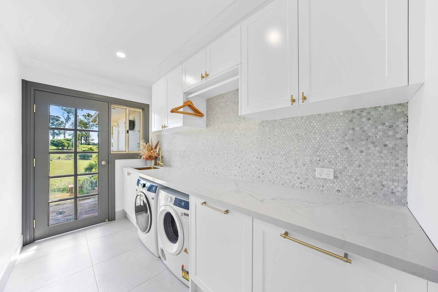 Bright White Laundry Room With Washer — Above & Beyond Interiors in Smeaton Grange, NSW