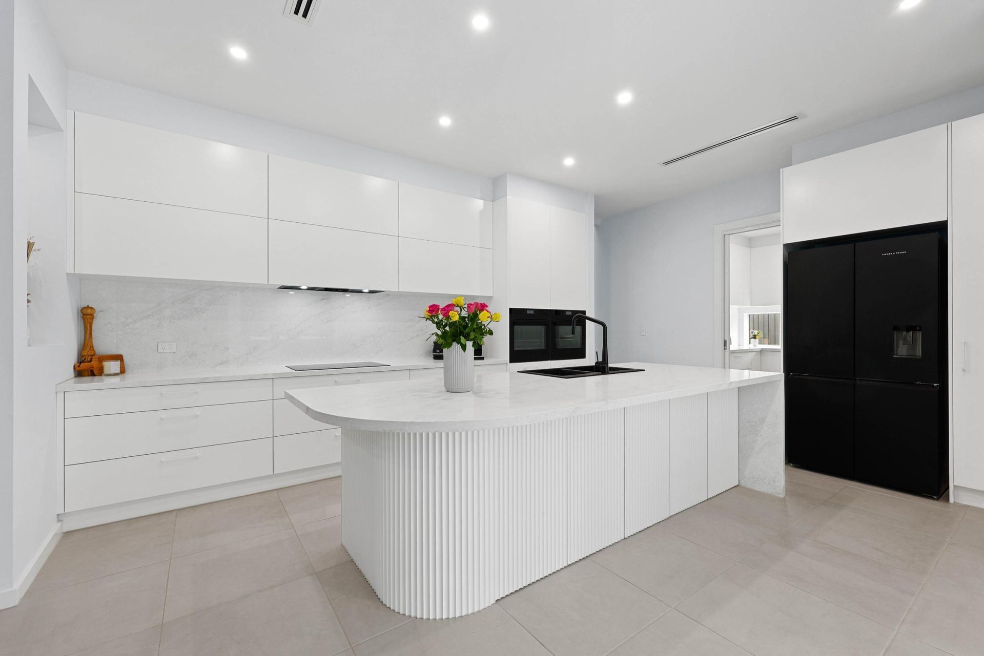 Bright Modern White Kitchen With Island, Black Refrigerator — Above & Beyond Interiors in Smeaton Grange, NSW