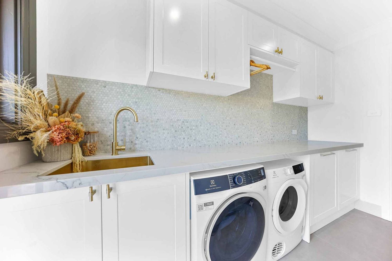 Bright Laundry Room With White Cabinets — Above & Beyond Interiors in Smeaton Grange, NSW