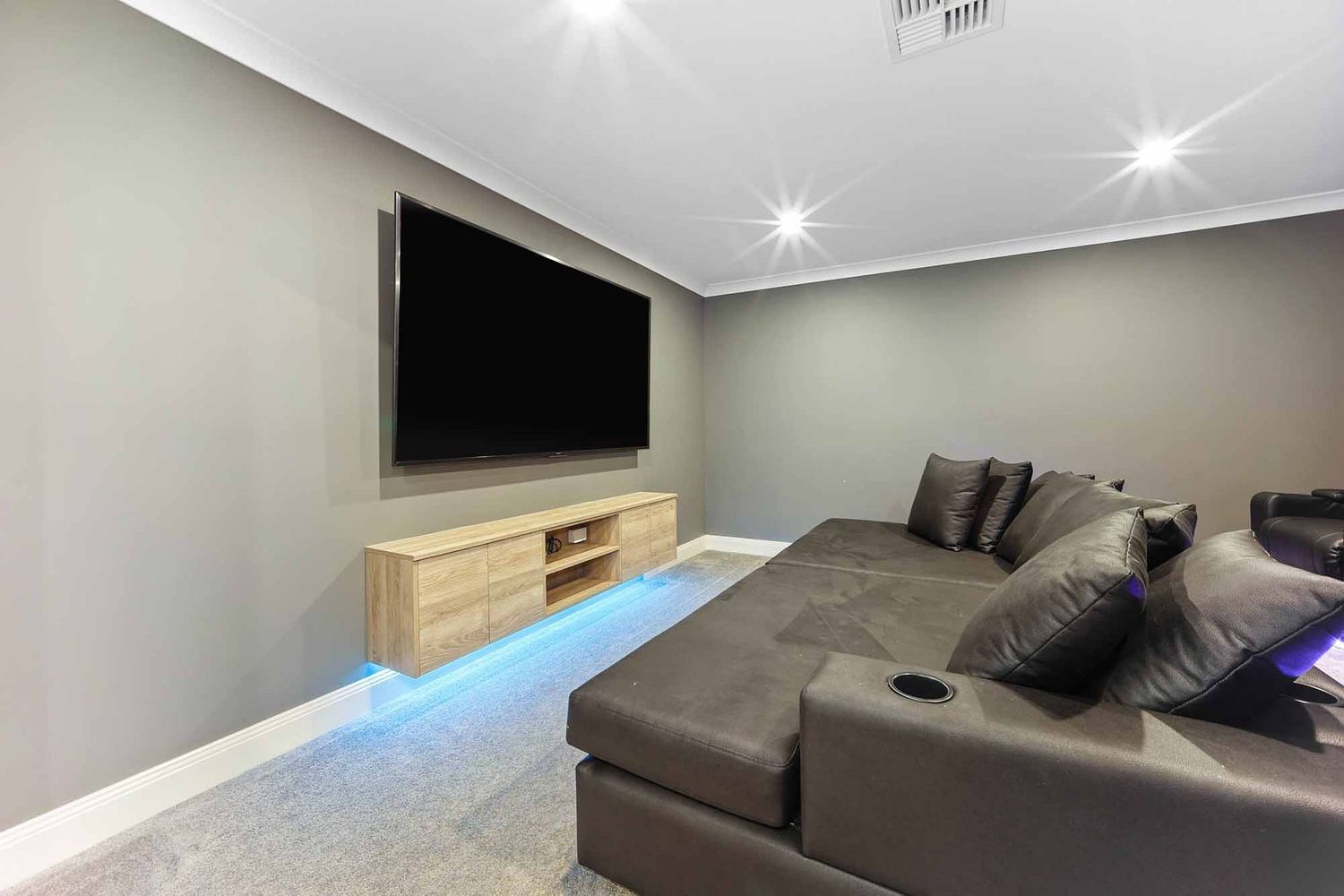 Modern Living Room With a Wall-mounted TV — Above & Beyond Interiors in Smeaton Grange, NSW