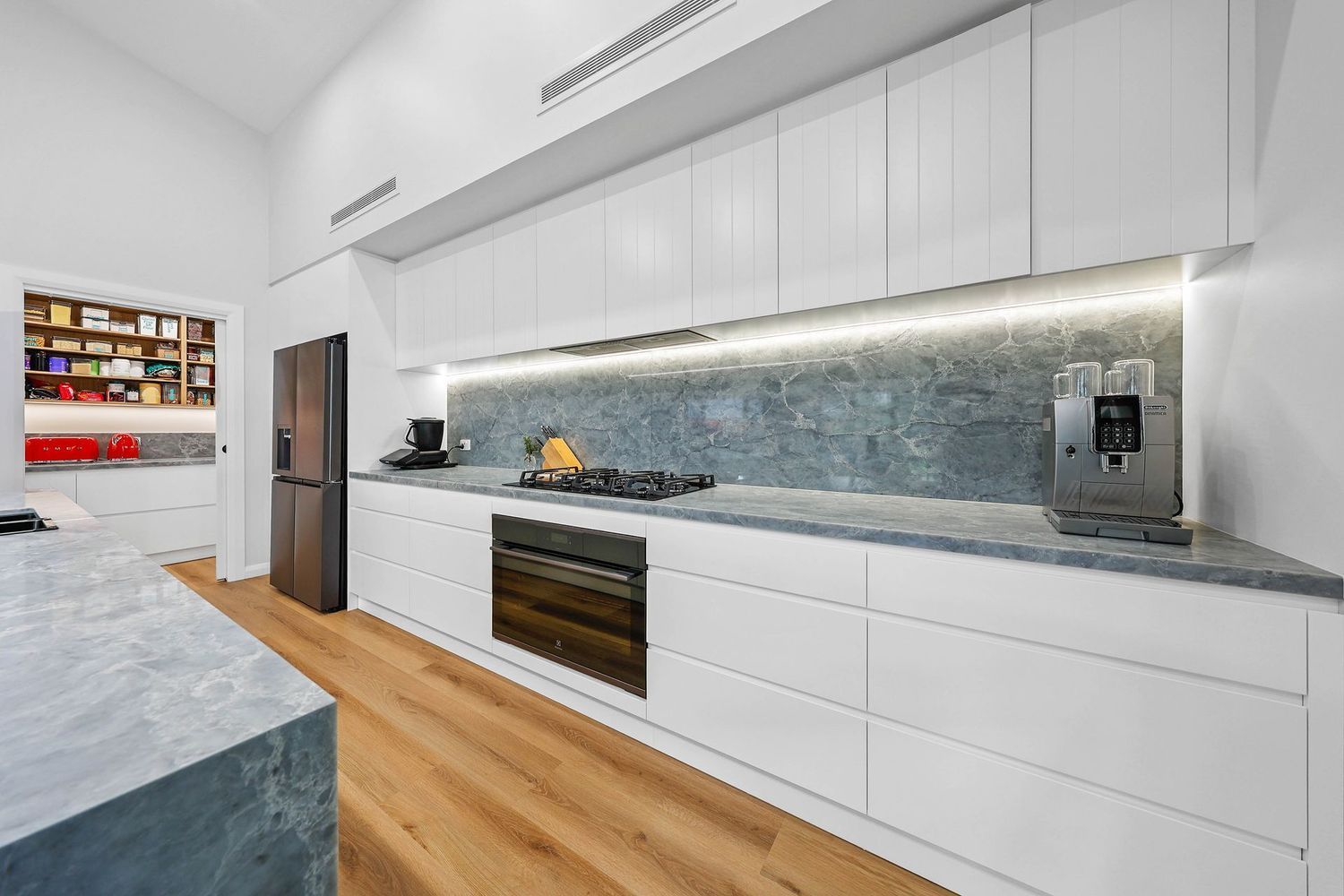 Modern White Kitchen With Wood Floor — Above & Beyond Interiors in Smeaton Grange, NSW