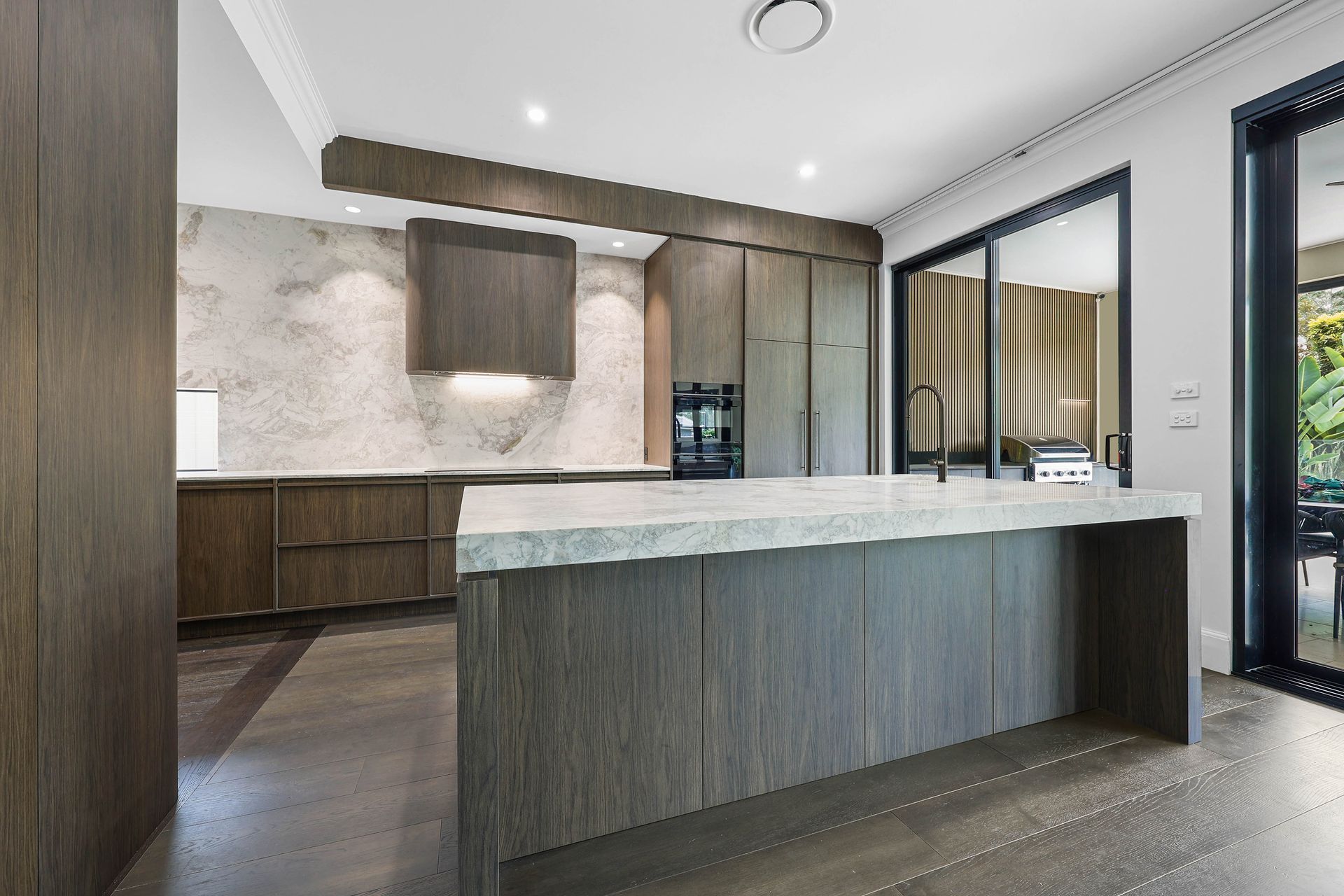 Modern Kitchen With Dark Wood Cabinets — Above & Beyond Interiors in Smeaton Grange, NSW