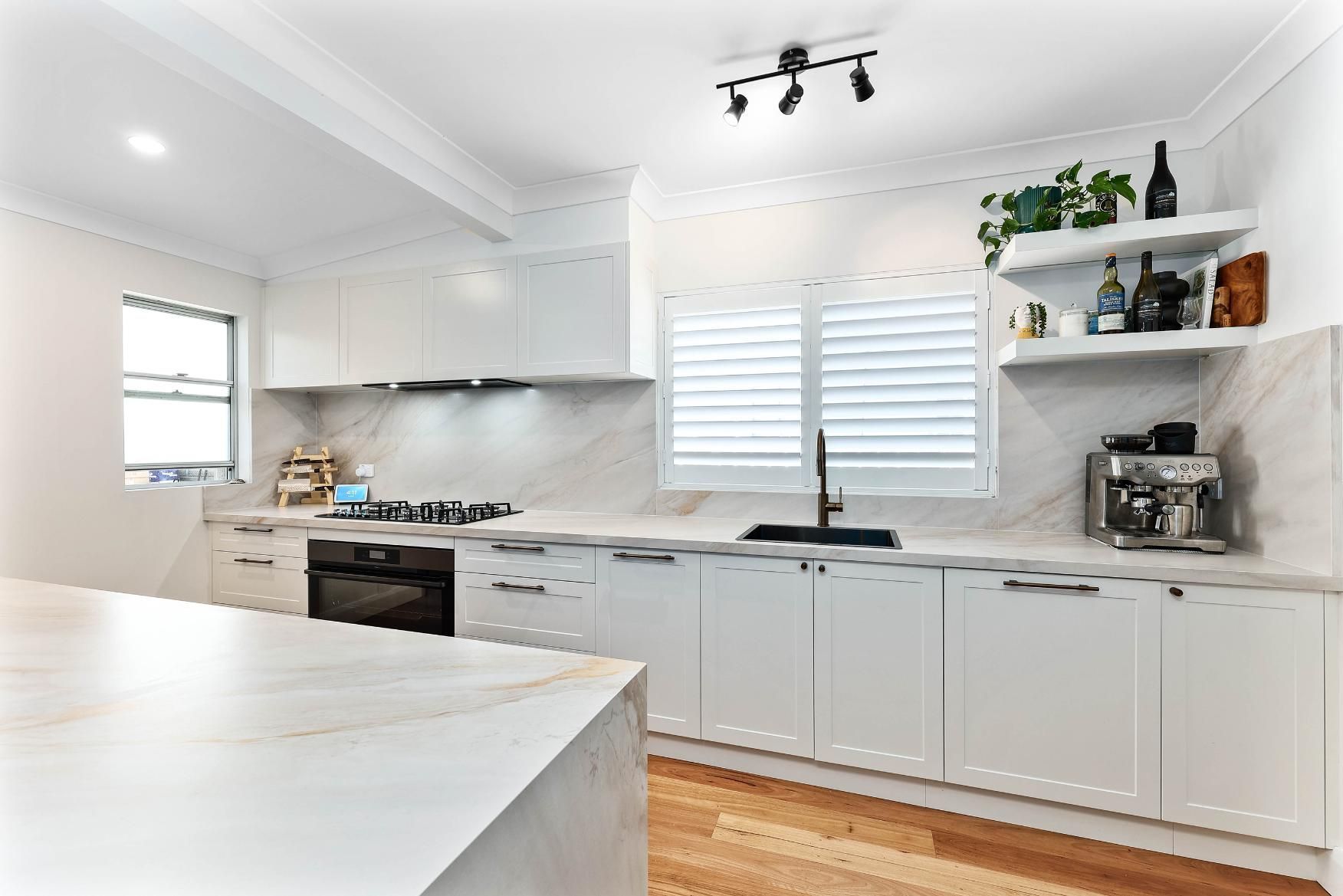 Bright White Kitchen With Gray Cabinets — Above & Beyond Interiors in Smeaton Grange, NSW