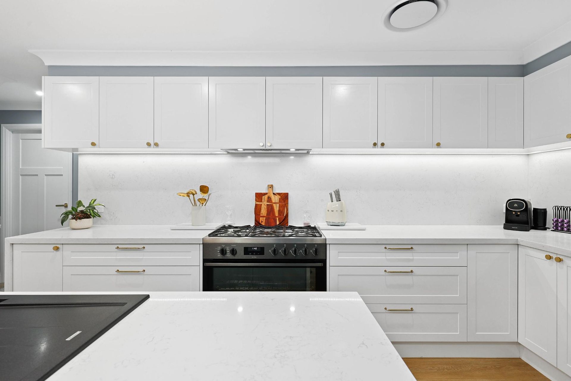 Bright Modern White Kitchen With Glossy Cabinets — Above & Beyond Interiors in Smeaton Grange, NSW