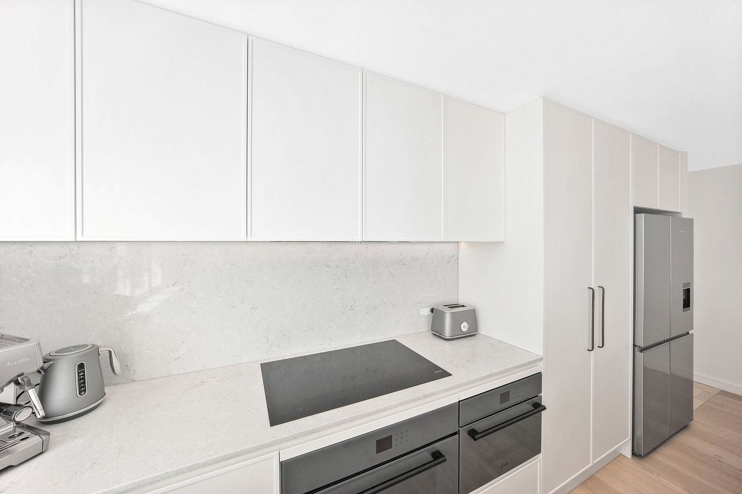 Modern White Kitchen With Stainless Steel Appliances — Above & Beyond Interiors in Smeaton Grange, NSW