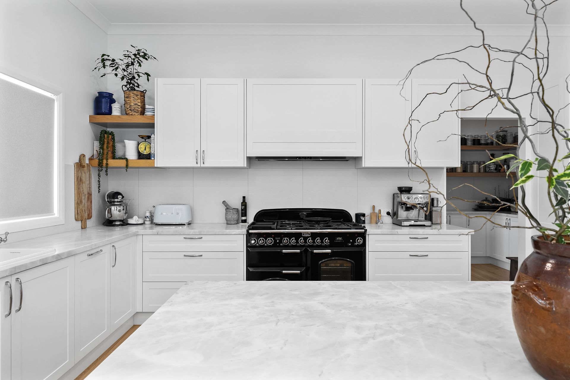 Modern White Kitchen With Black Stove, White Cabinets — Above & Beyond Interiors in Smeaton Grange, NSW