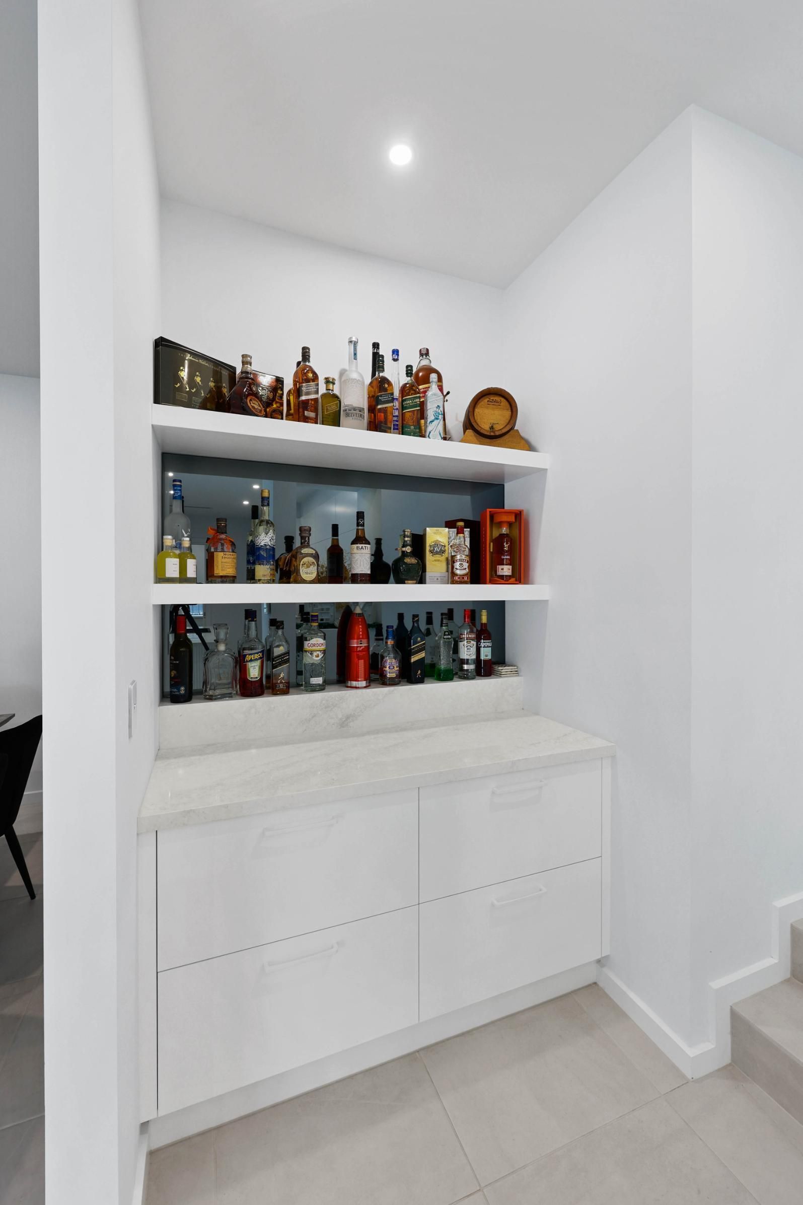 Built-in Bar Nook With Liquor Bottles on Shelves — Above & Beyond Interiors in Smeaton Grange, NSW