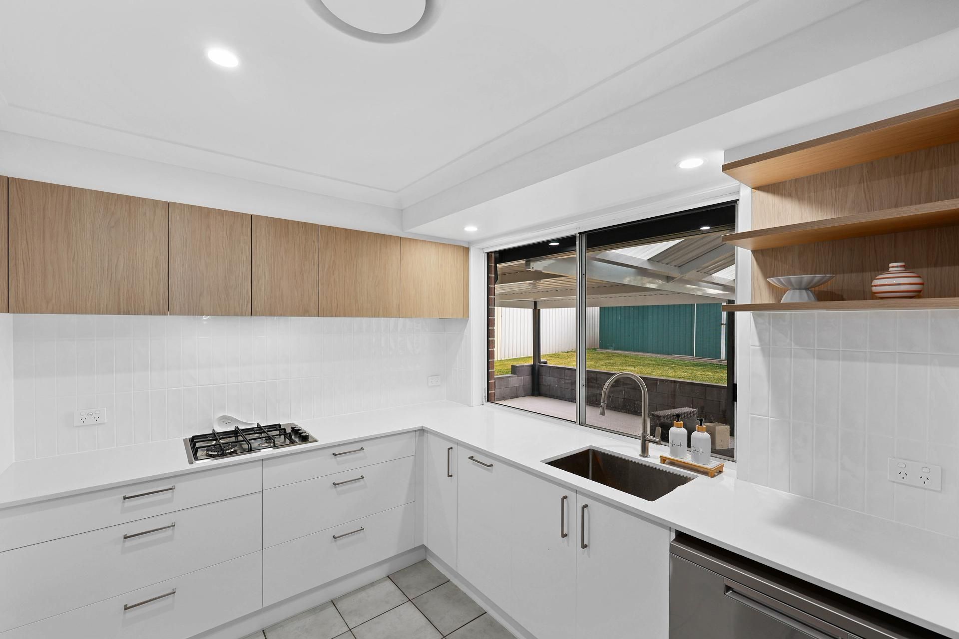 Modern White Kitchen With Wood Accents — Above & Beyond Interiors in Smeaton Grange, NSW