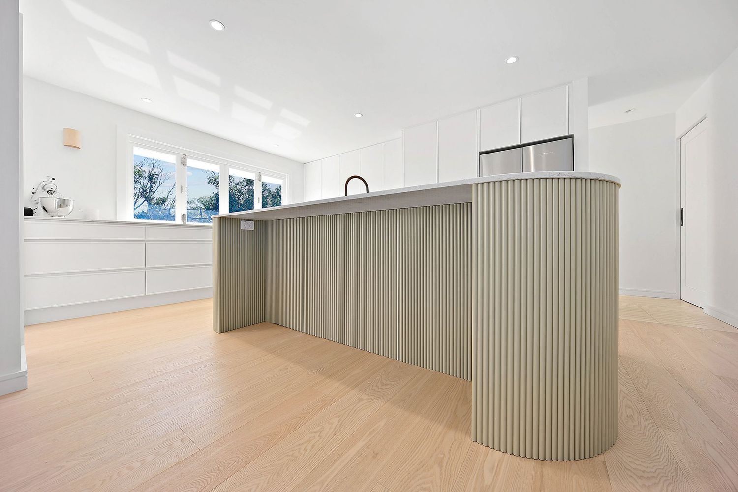 Modern White Kitchen With a Curved Gray Island — Above & Beyond Interiors in Smeaton Grange, NSW