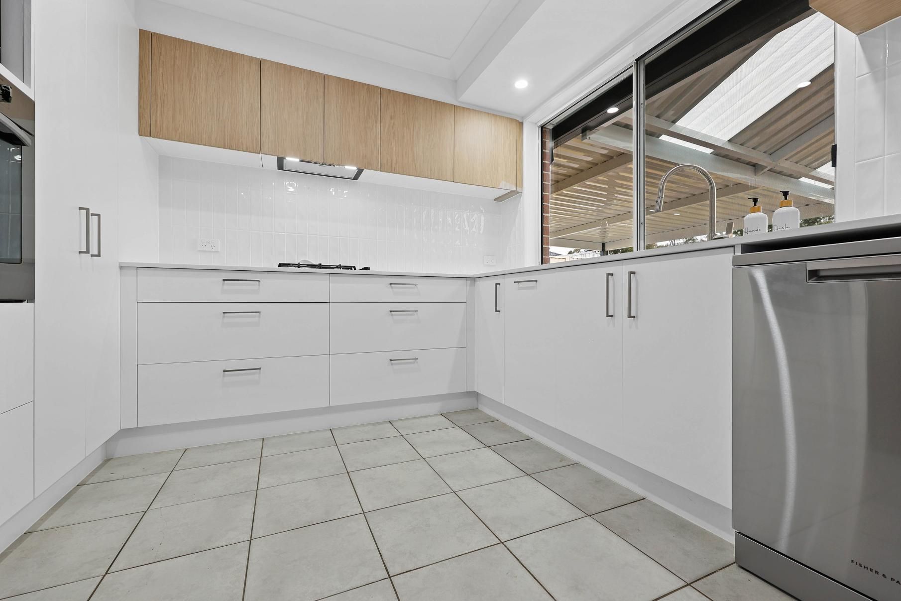 Modern White Kitchen With Light Wood Cabinets — Above & Beyond Interiors in Smeaton Grange, NSW