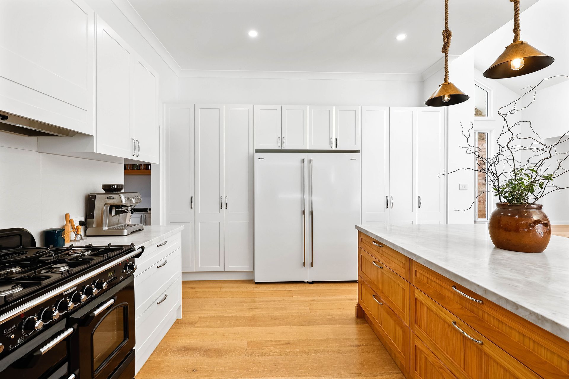 Bright White Kitchen With Island, Wooden Floor — Above & Beyond Interiors in Smeaton Grange, NSW