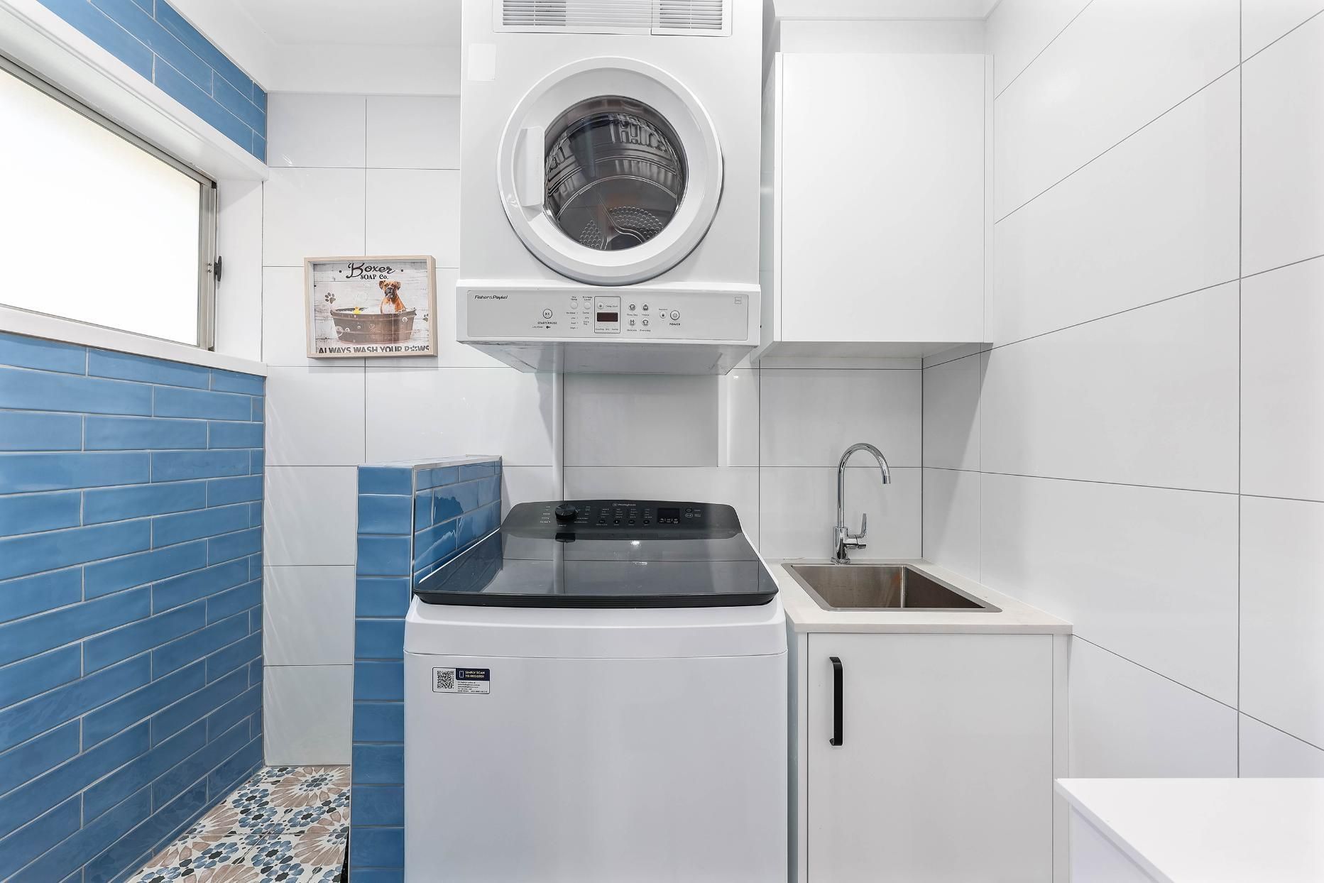 Compact Laundry Room With Stacked Washer-dryer — Above & Beyond Interiors in Smeaton Grange, NSW