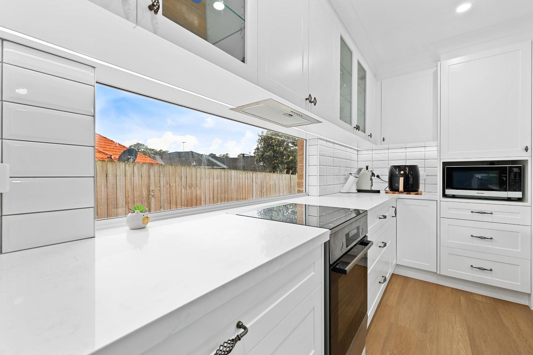 Bright White Modern Kitchen With Island — Above & Beyond Interiors in Smeaton Grange, NSW
