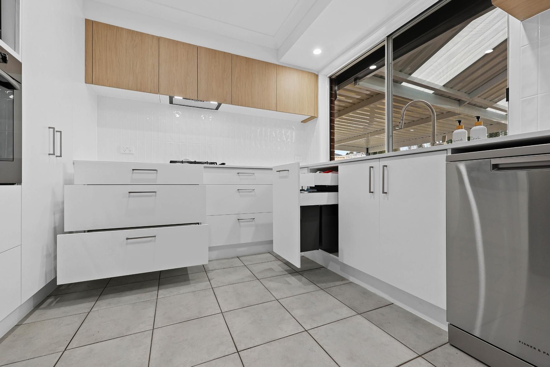 Modern White Kitchen With Tiled Floor, Wooden Upper Cabinets — Above & Beyond Interiors in Smeaton Grange, NSW