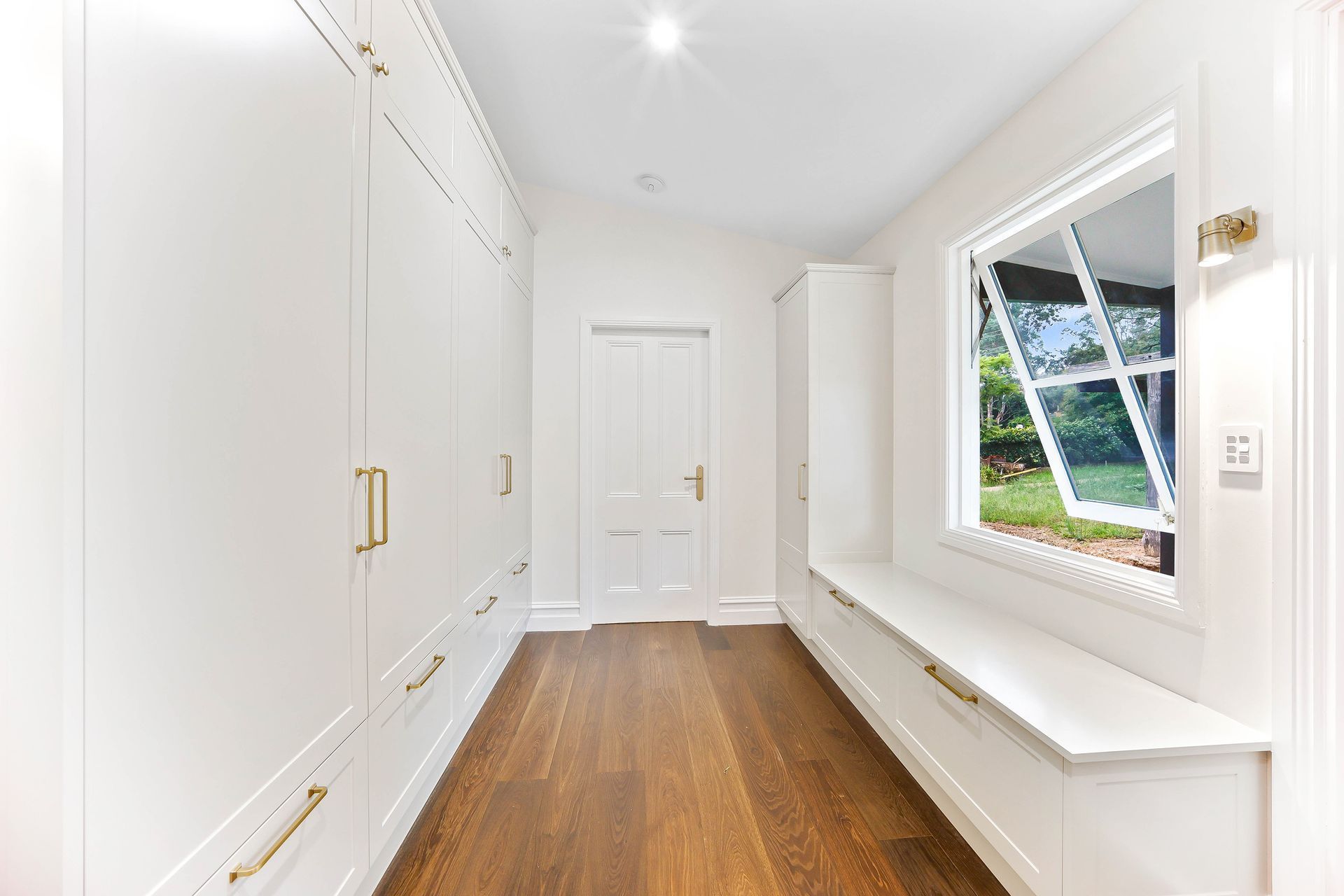 Bright White Hallway With Wood Floor, Built-in Cabinets — Above & Beyond Interiors in Smeaton Grange, NSW