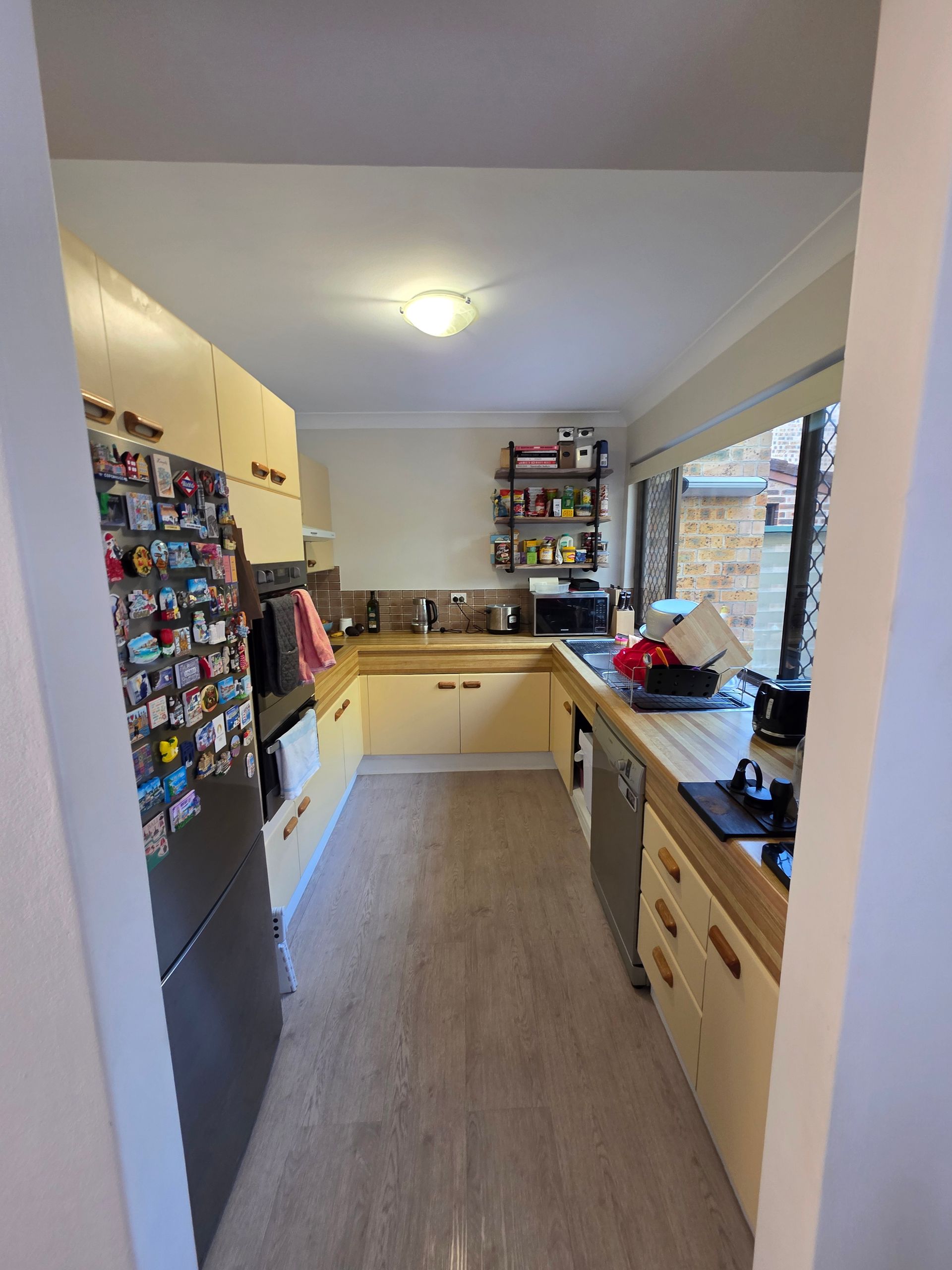 A Narrow Kitchen with Cream Cabinets — Above & Beyond Interiors in Smeaton Grange, NSW