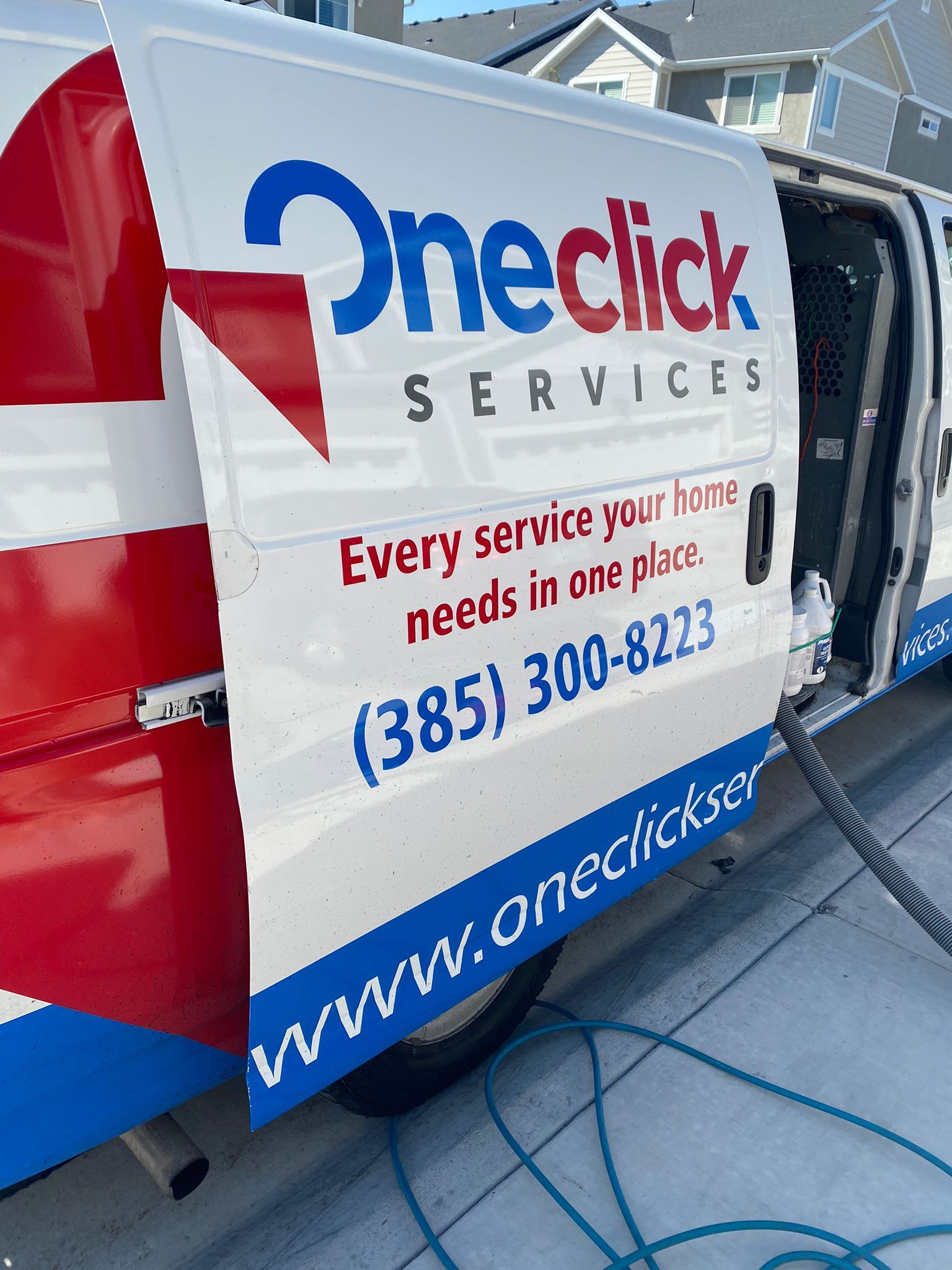 A oneclick services van is parked on the side of the road