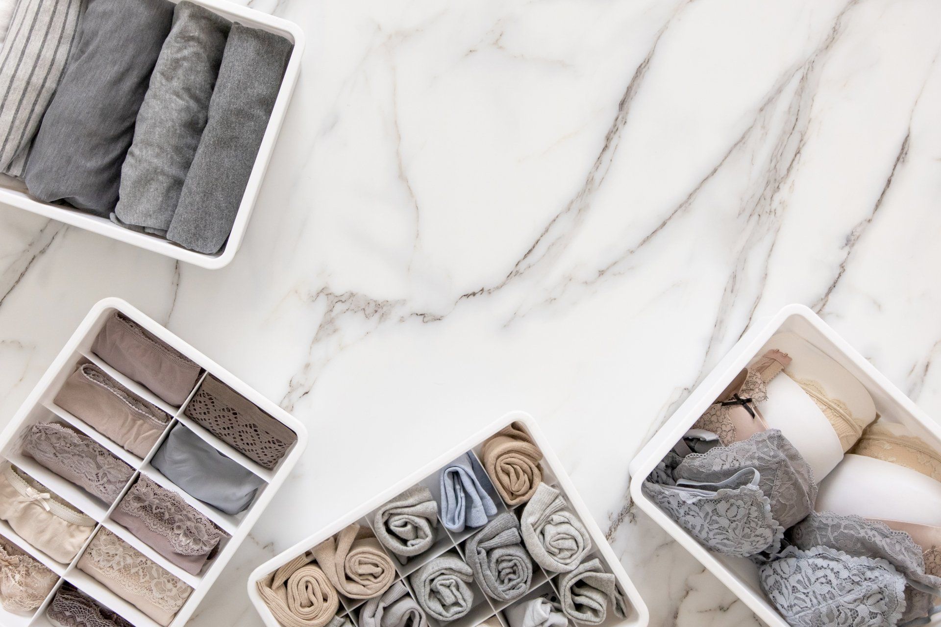 A bunch of boxes filled with towels and socks on a marble surface.