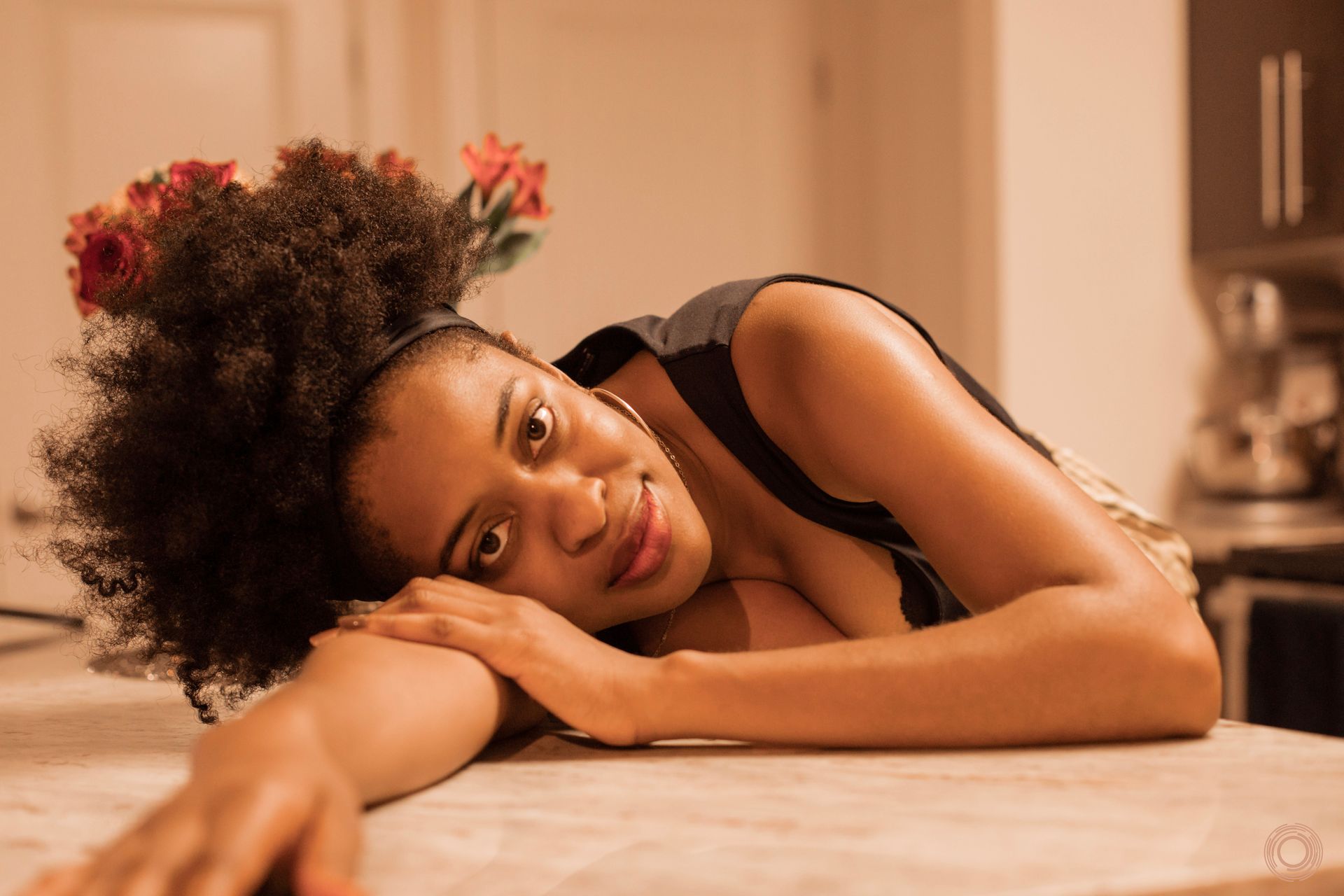 A woman is laying on a counter with her head on her arm.