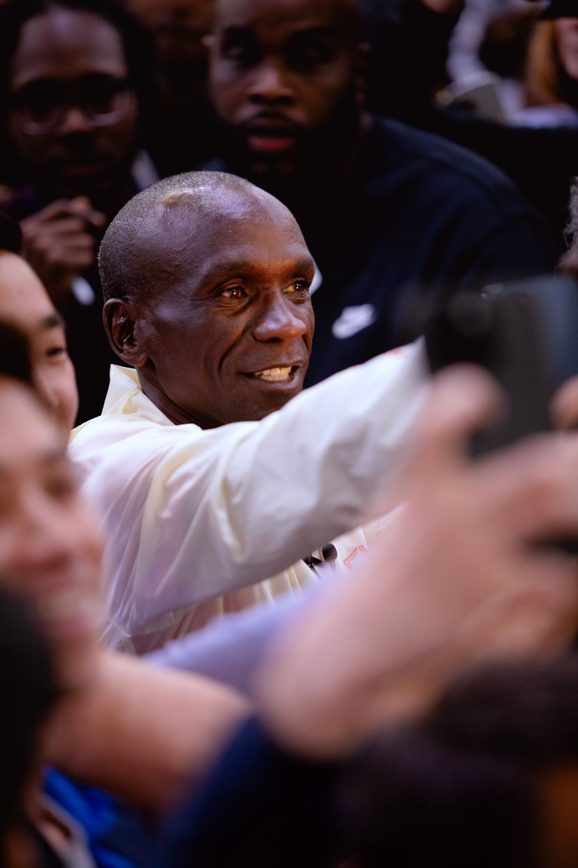 A man is taking a selfie in a crowd of people.