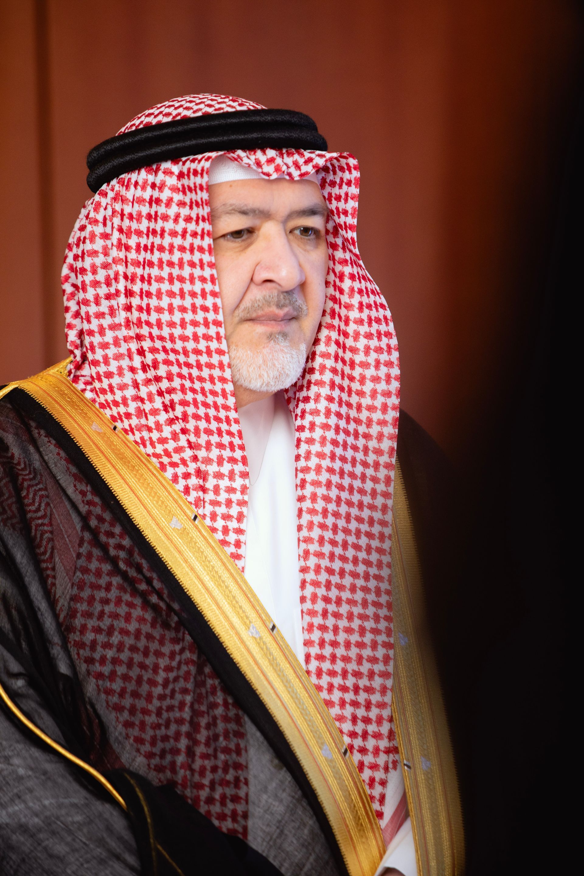 A man with a beard wearing a keffiyeh and a robe