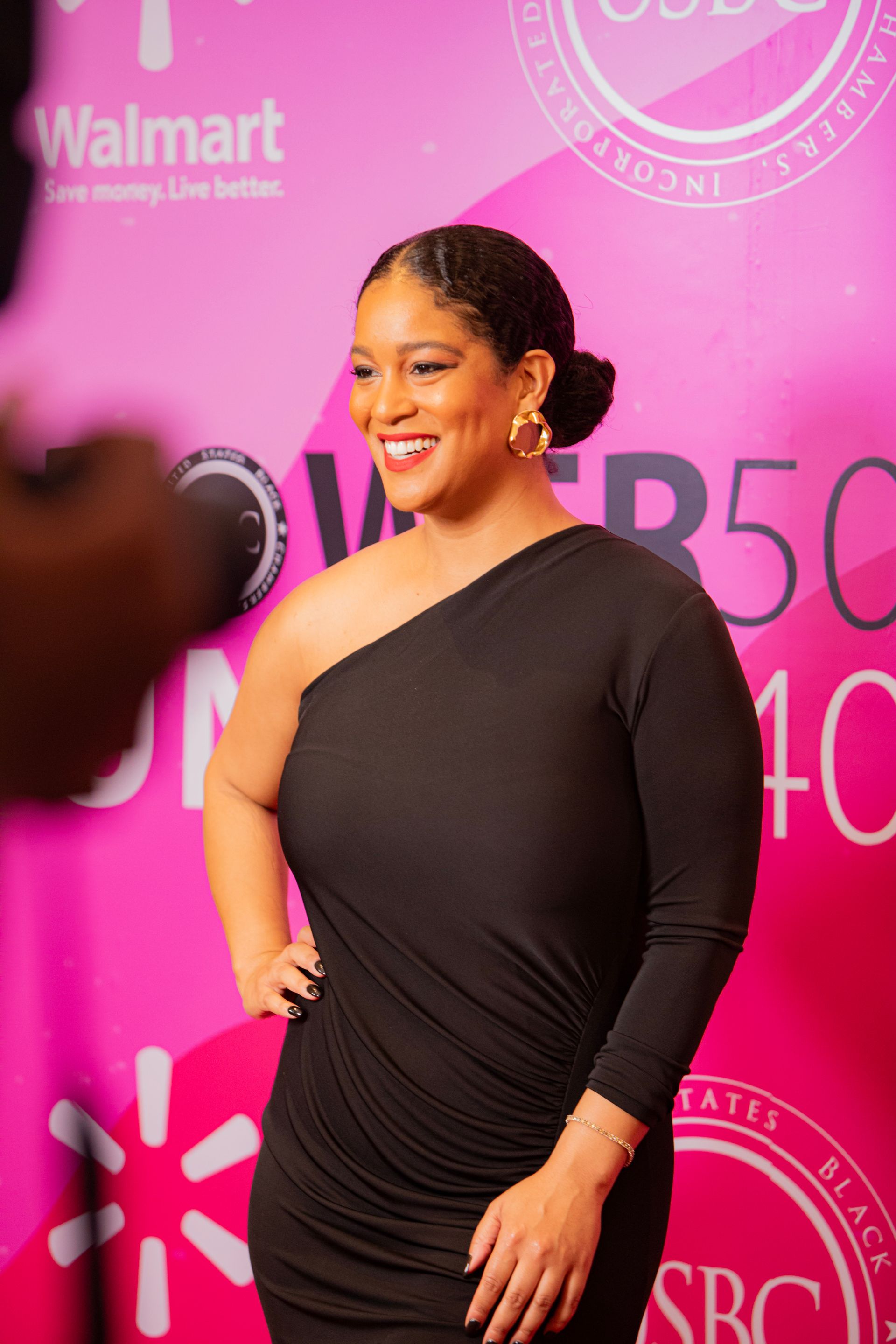 A woman in a black dress is standing in front of a walmart sign