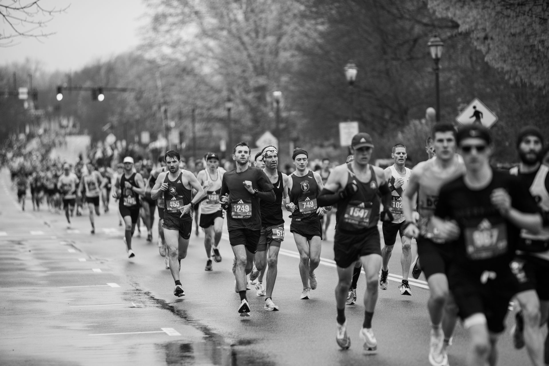 A black and white photo of a group of people running a marathon.