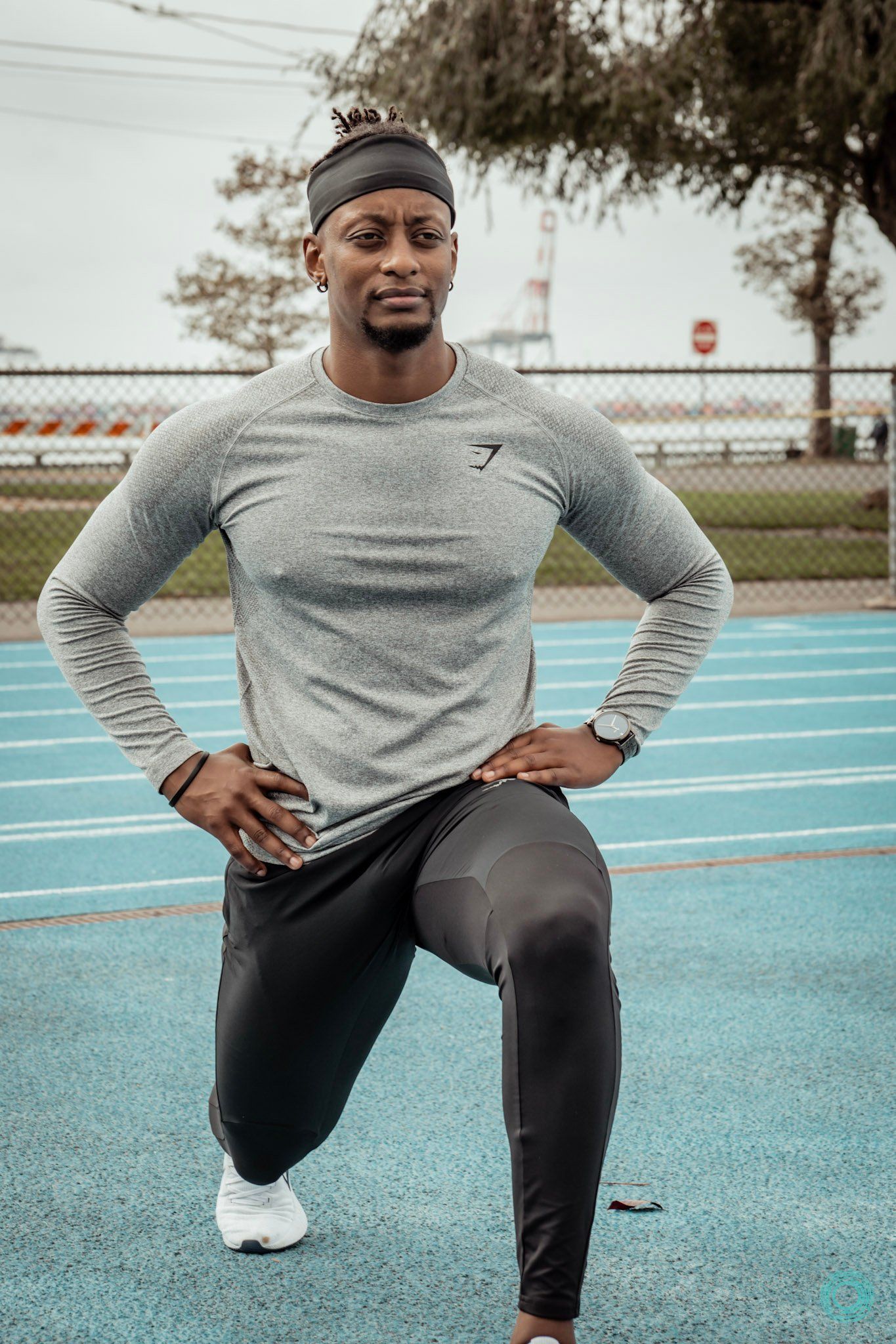 A man is stretching his legs on a track.