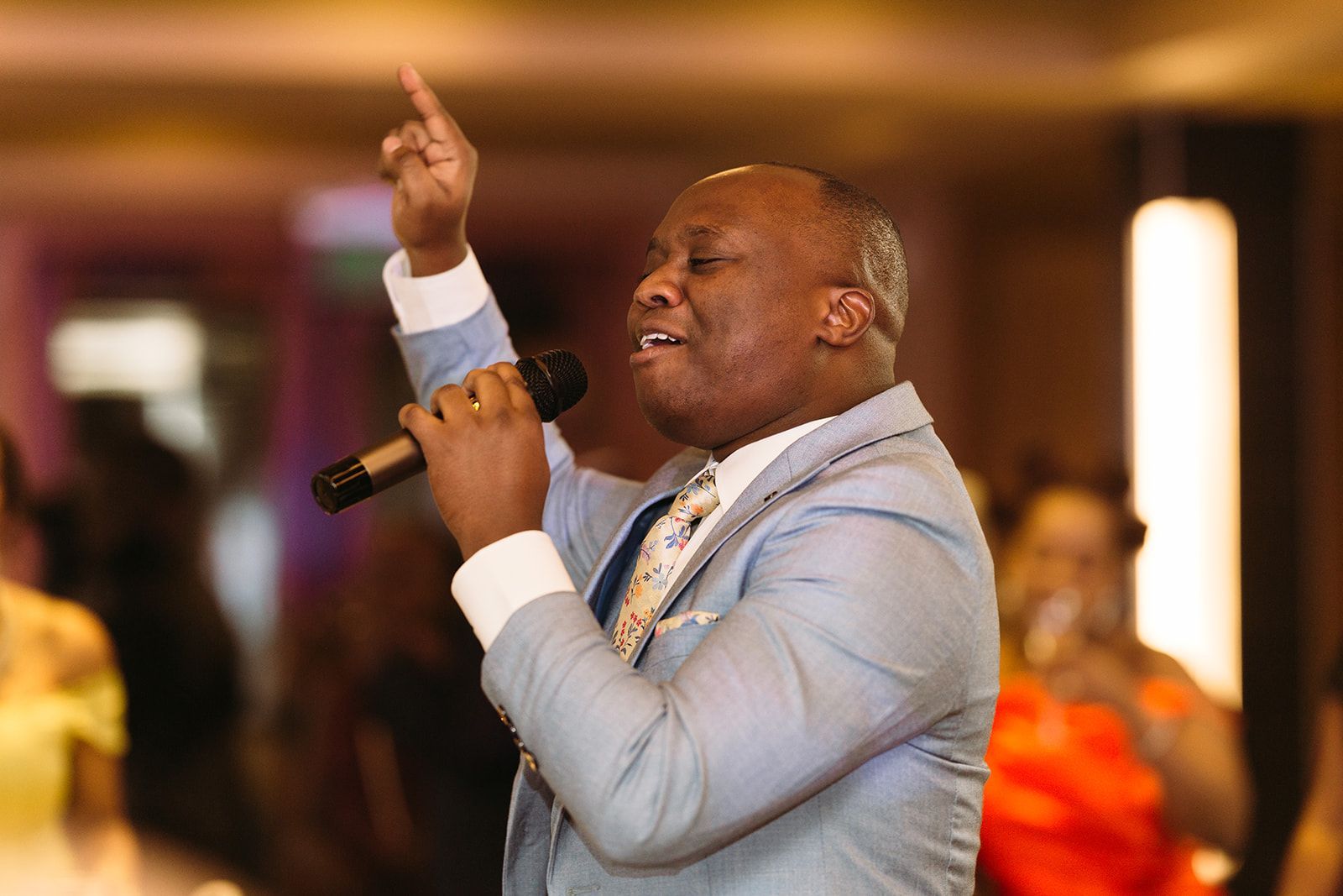 A man in a suit is singing into a microphone.