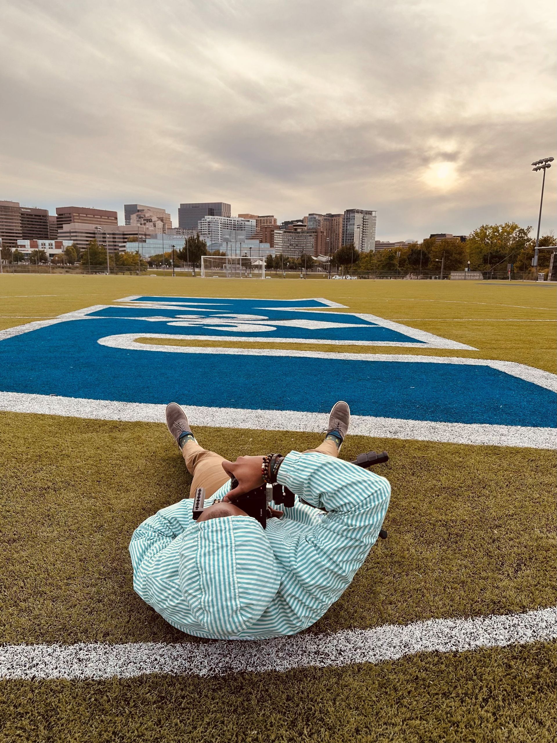 A person is laying on top of a football field.