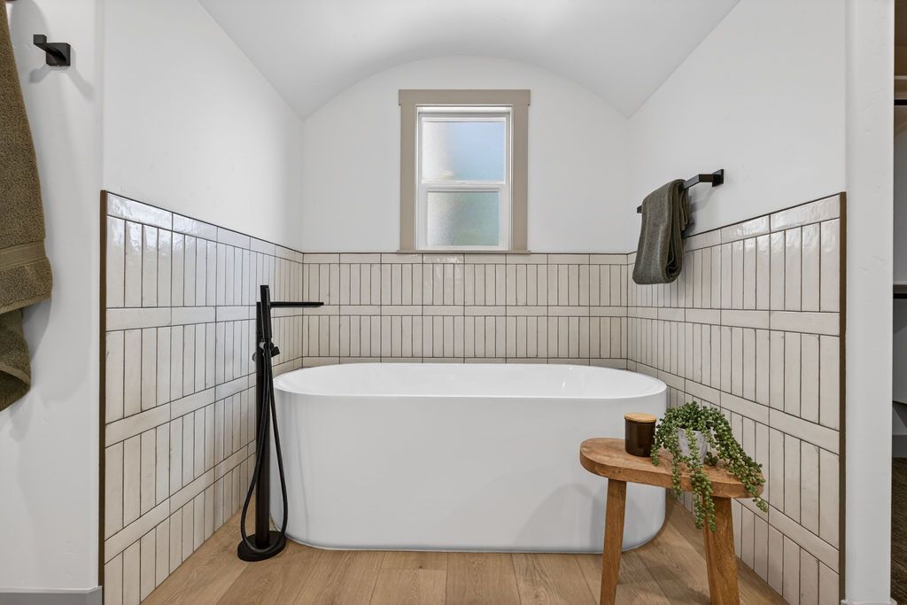 Small bathroom with blue tiled shower, white sink vanity, and patterned floor tiles.