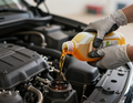 Technician pouring oil into an engine