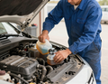 Technician topping off coolant