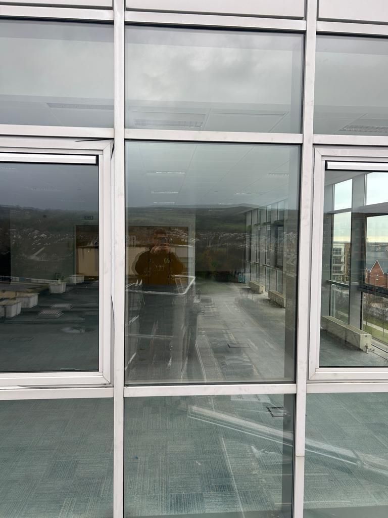 A building with a lot of windows and a reflection of a building in the windows.