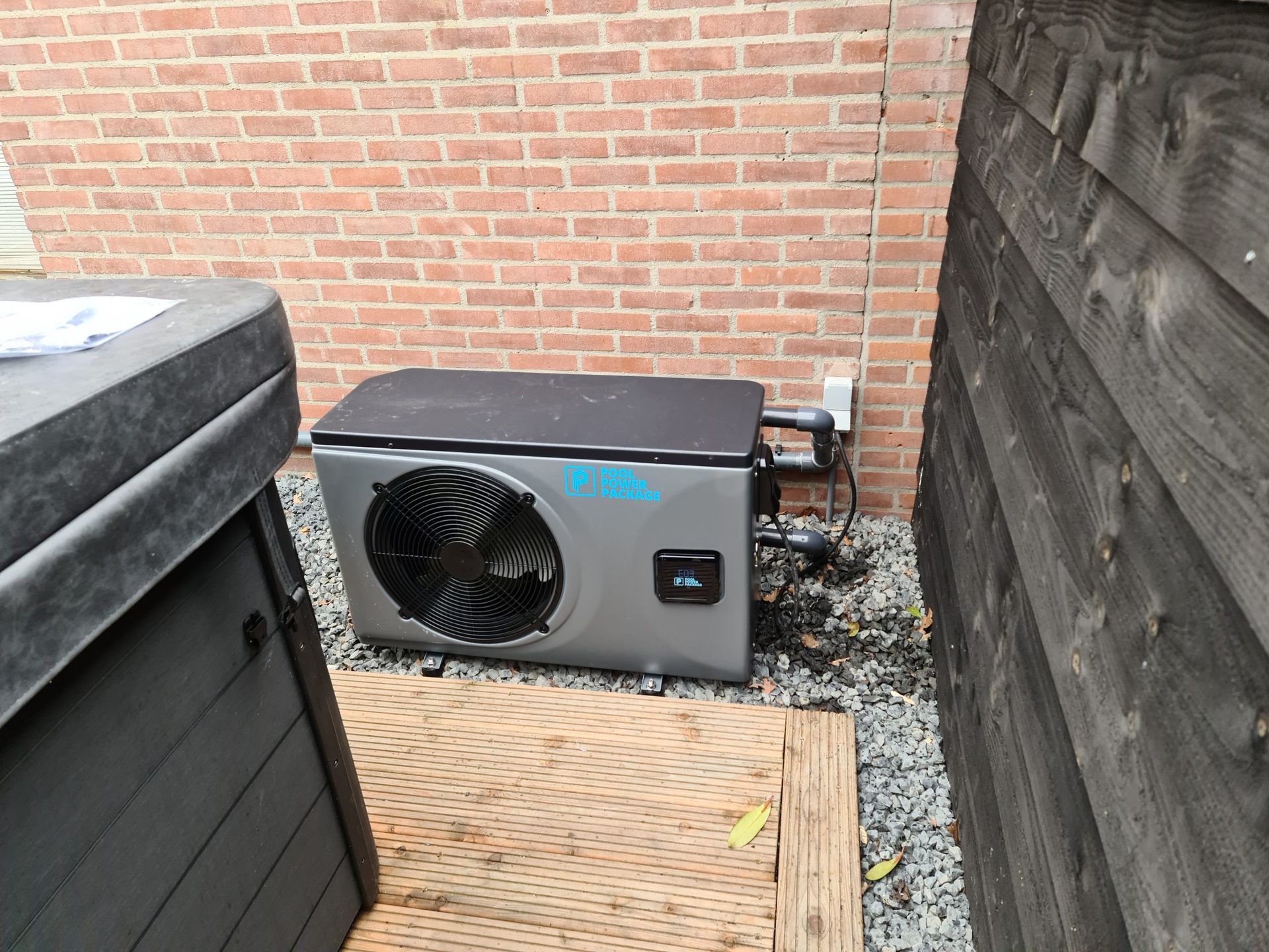 Er staat een hottub naast een grote airconditioner.