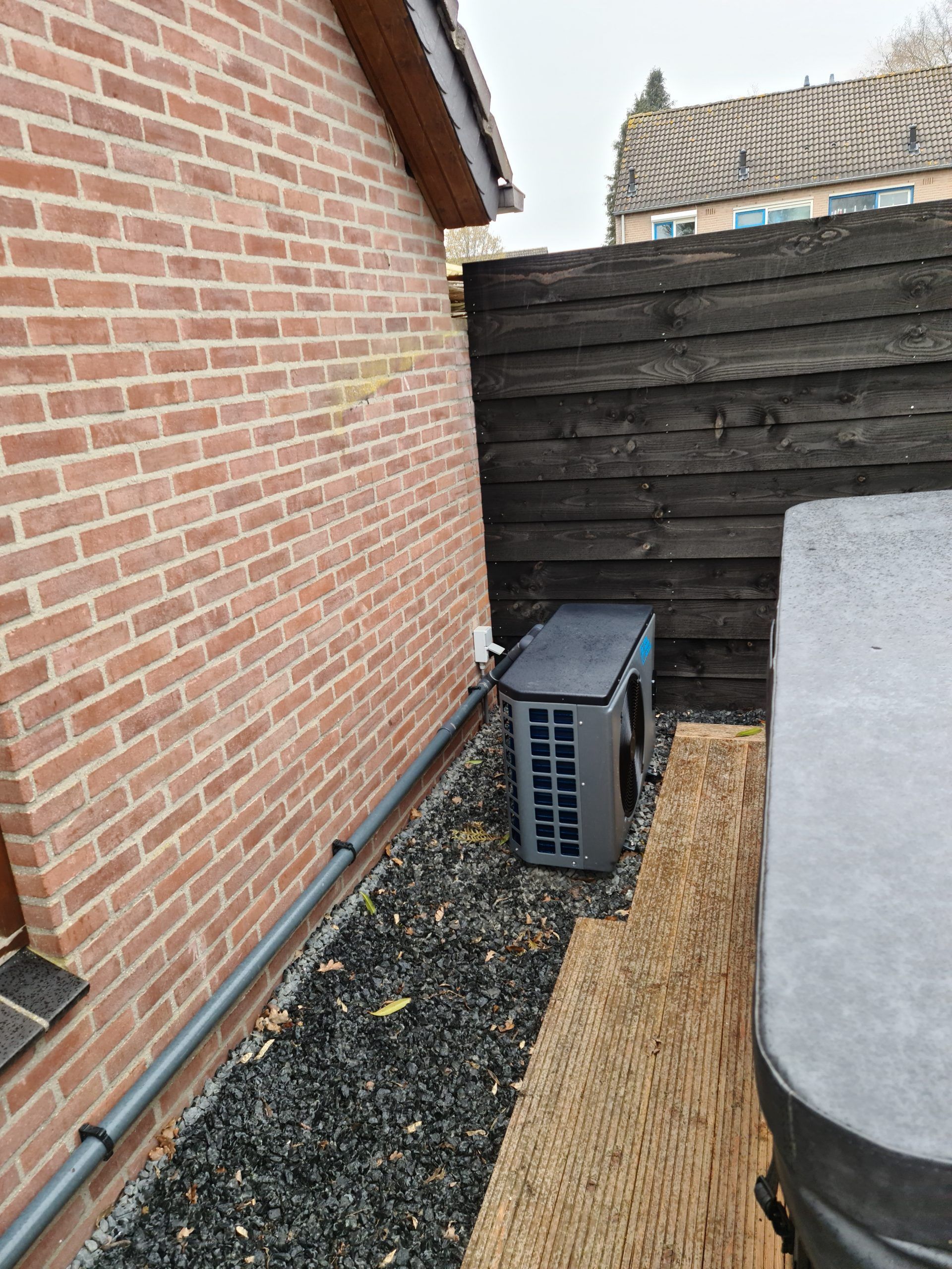 Er staat een hottub naast een bakstenen muur.