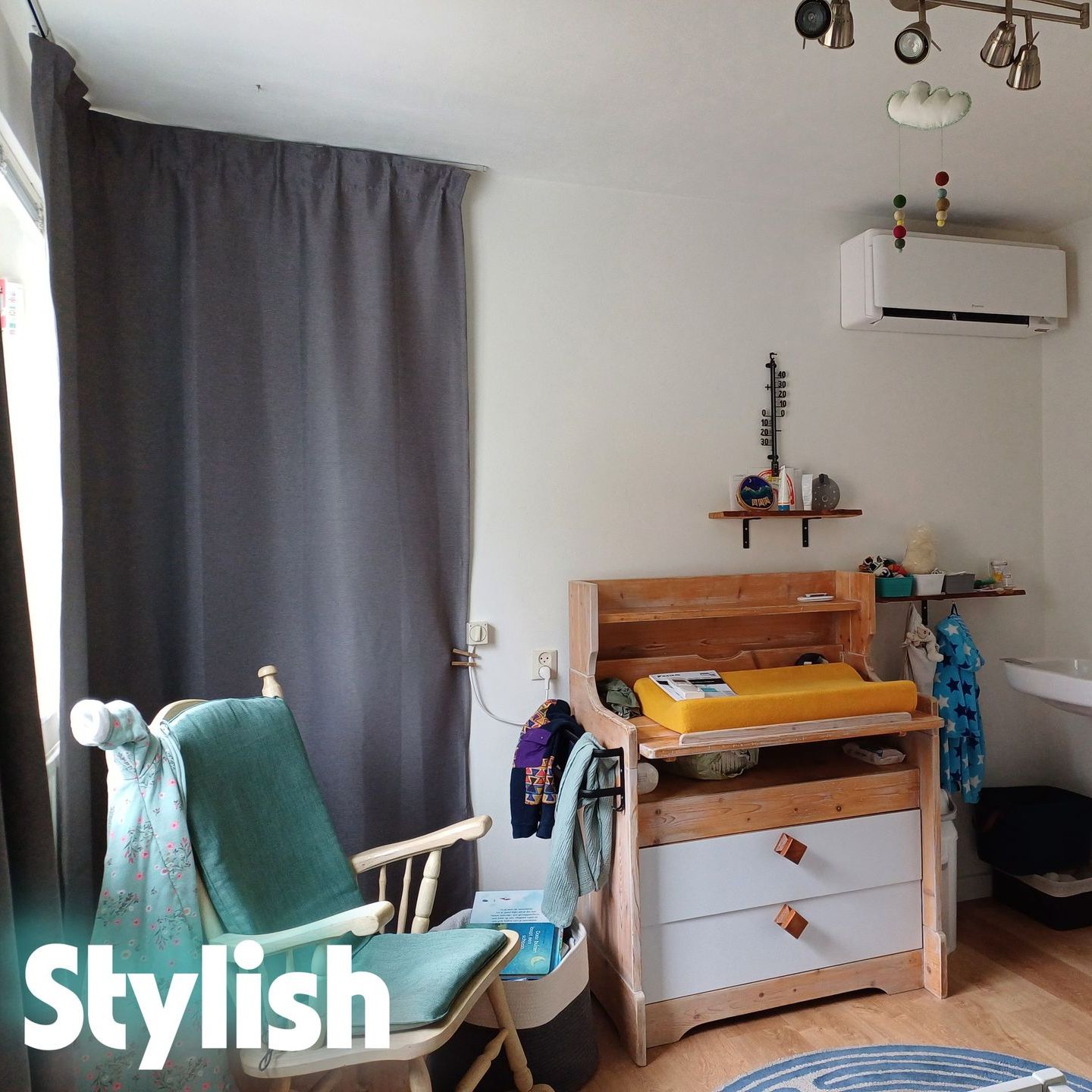 Kinderkamer met een Daikin Stylish wandmodel airco boven de commode, gecombineerd met natuurlijke houten meubels, een wasbak en zachte inrichtingselementen.