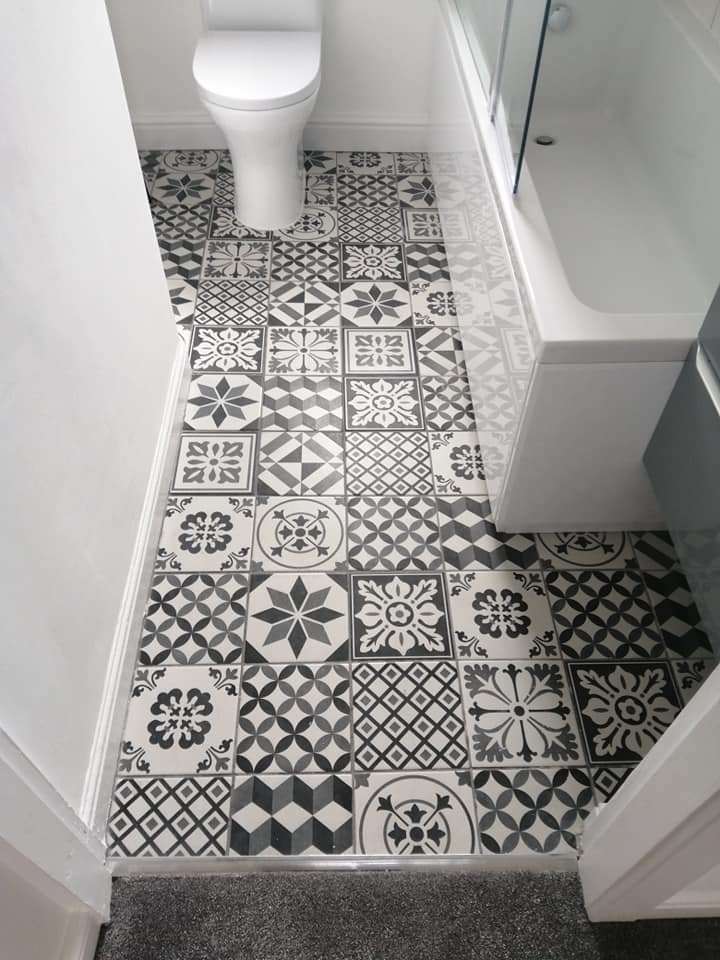 A bathroom with black and white tiles and a toilet