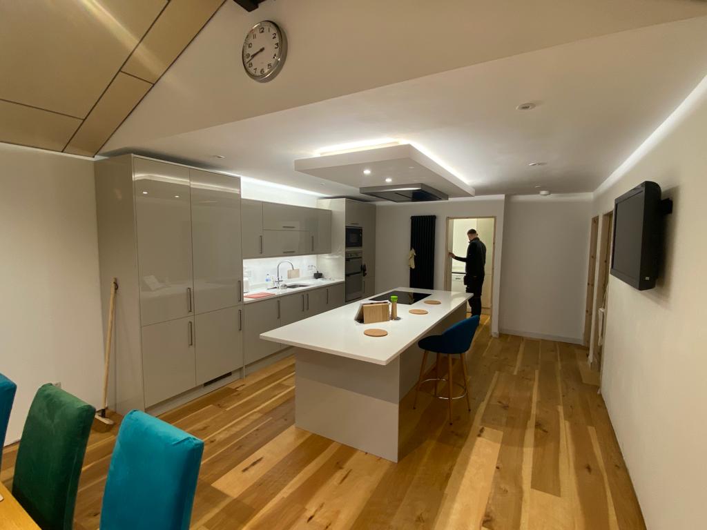 A kitchen with a large island and a clock on the ceiling.