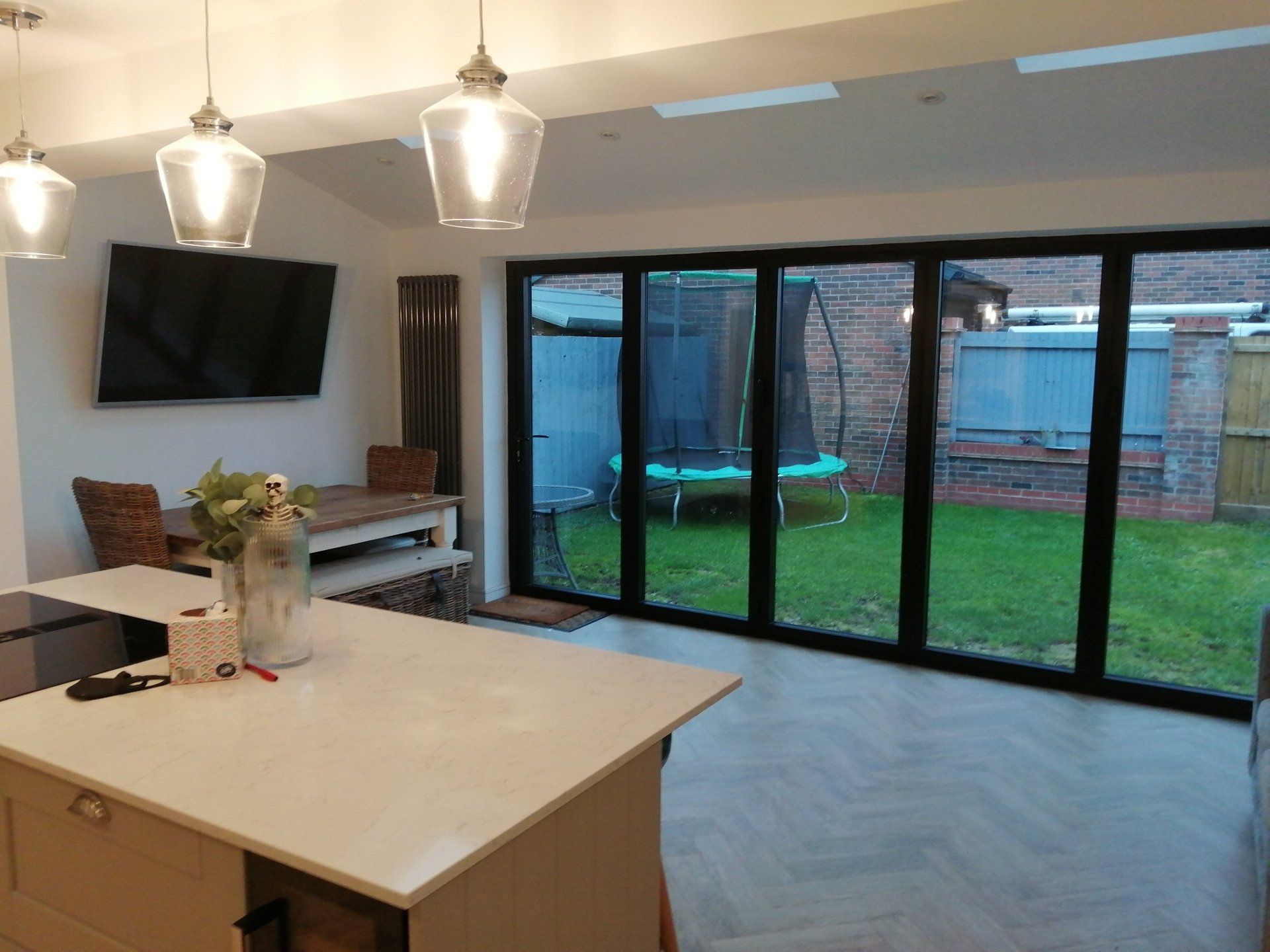 A kitchen with a lot of windows and a tv on the wall.