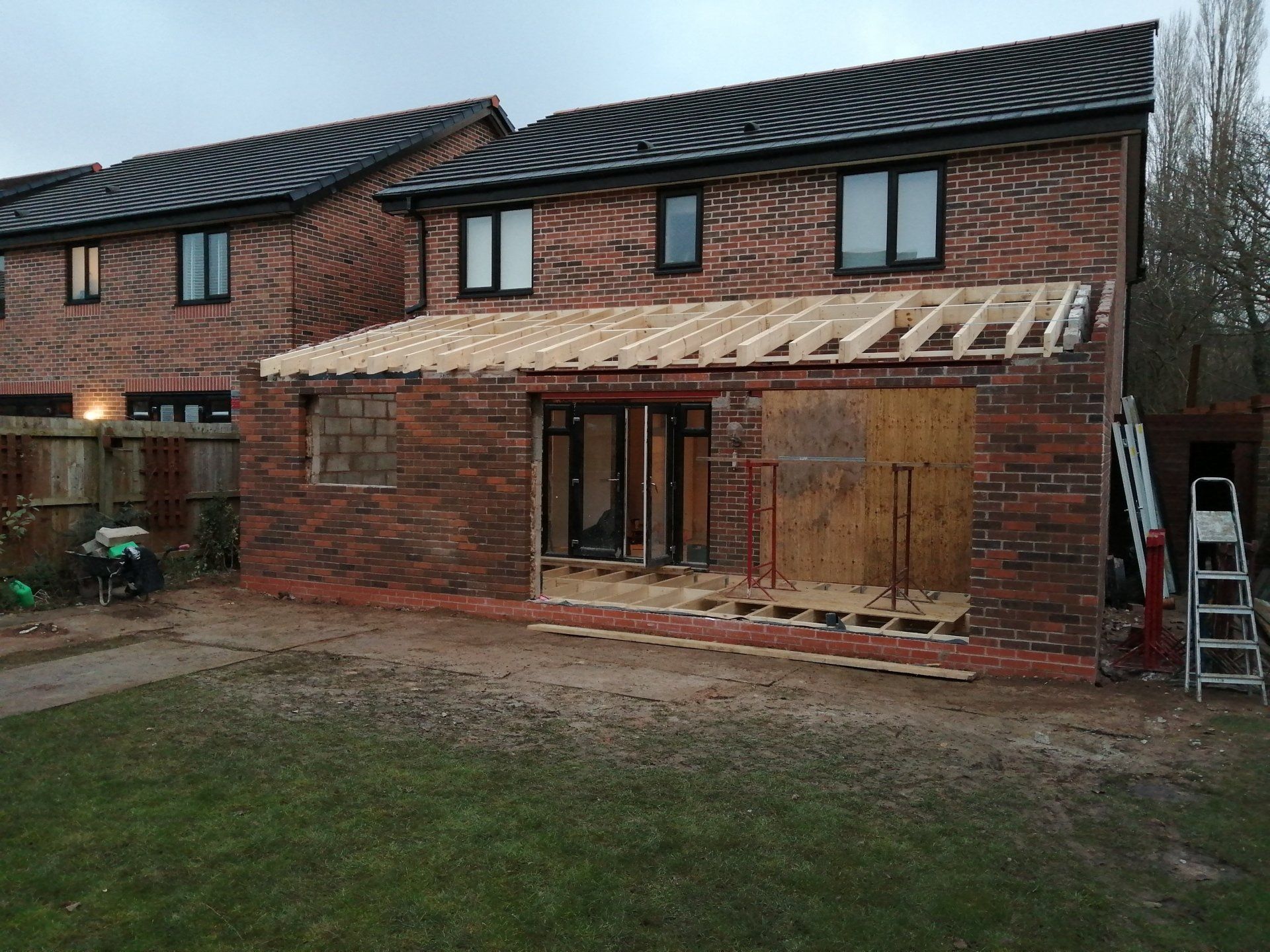 A brick house with a wooden roof is being built.