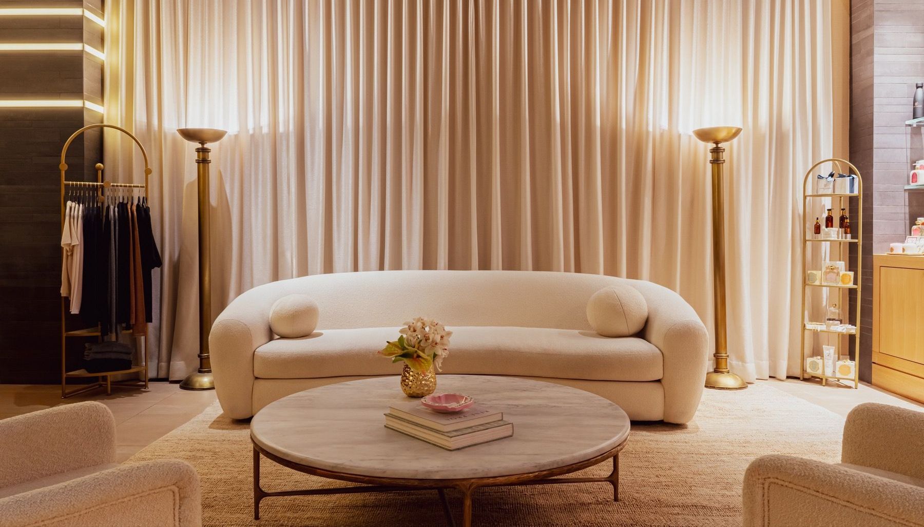 A living room with a couch , table , chairs and curtains.