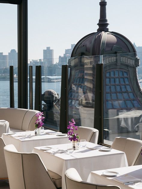 A restaurant with tables and chairs and a view of the city